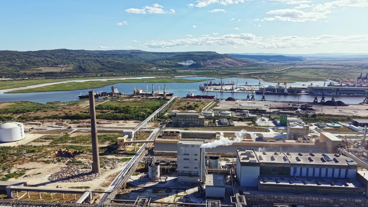 Local industrial com atividade de transporte ao longo do rio perto de uma área de manufatura durante o dia