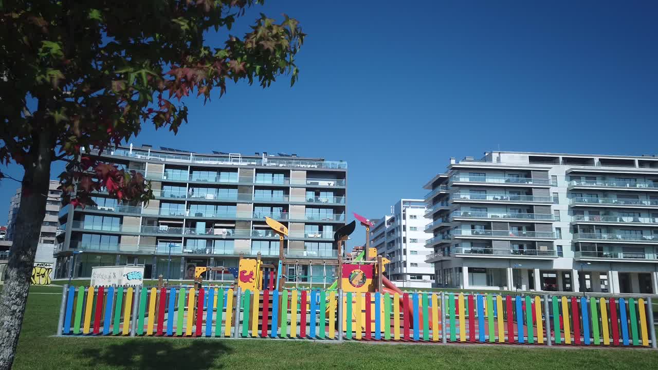 parque infantil con edificio de apartamentos de peaje en el fondo