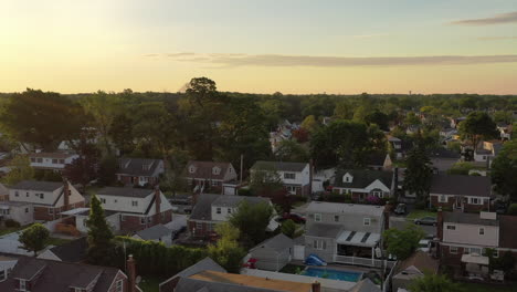 an aerial view over a middle class suburban neighborhood on long island, ny at sunrise