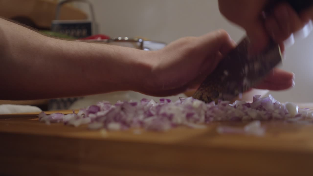 Chopping onion with sharp knife on a cut board