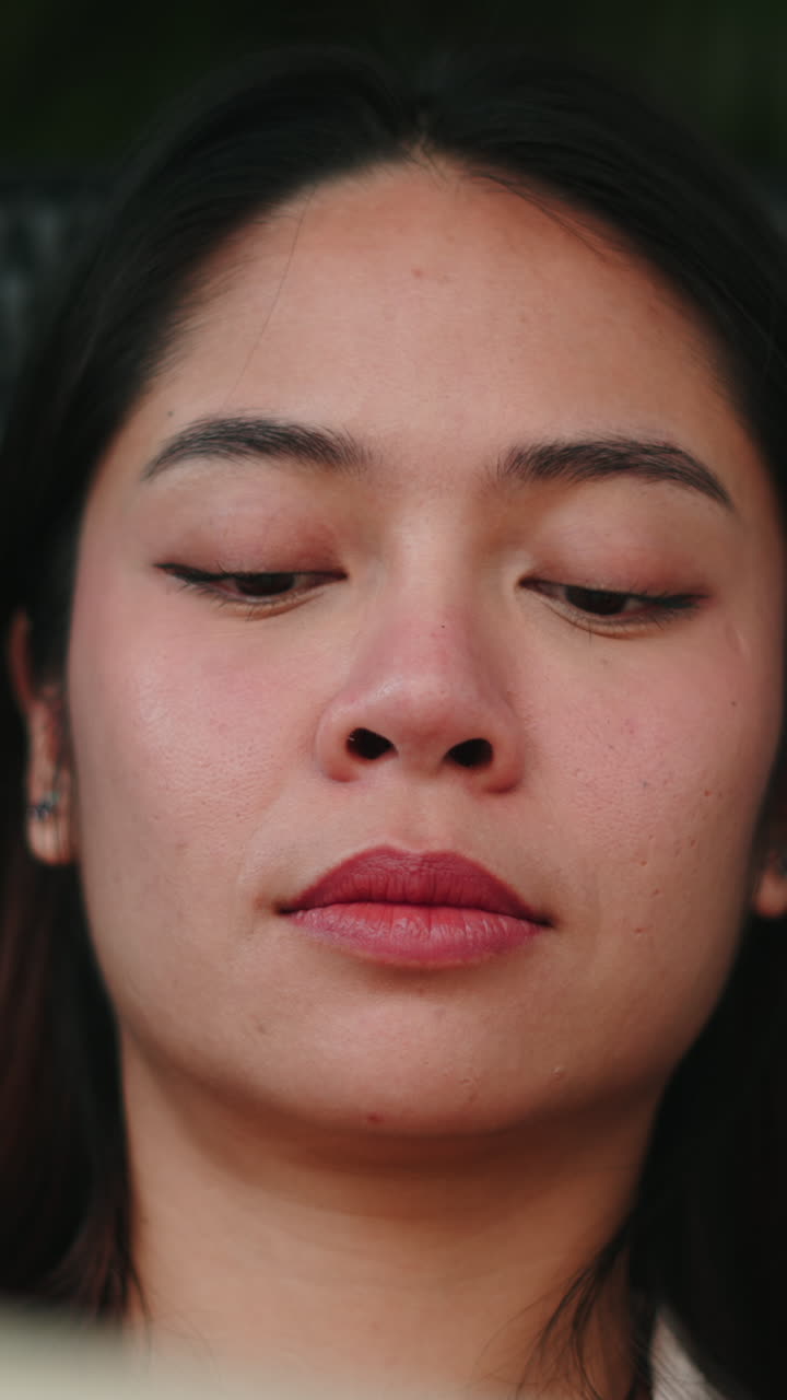 Close-up Wanita Asia Muda Menunduk dengan Ekspresi Fokus