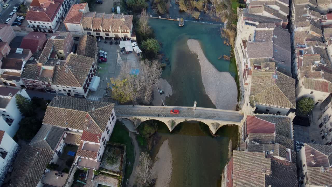 4K Aerial Drone Shot of Medieval Arch Bridge Over Blue River Surrounded by Historic Village in Spain