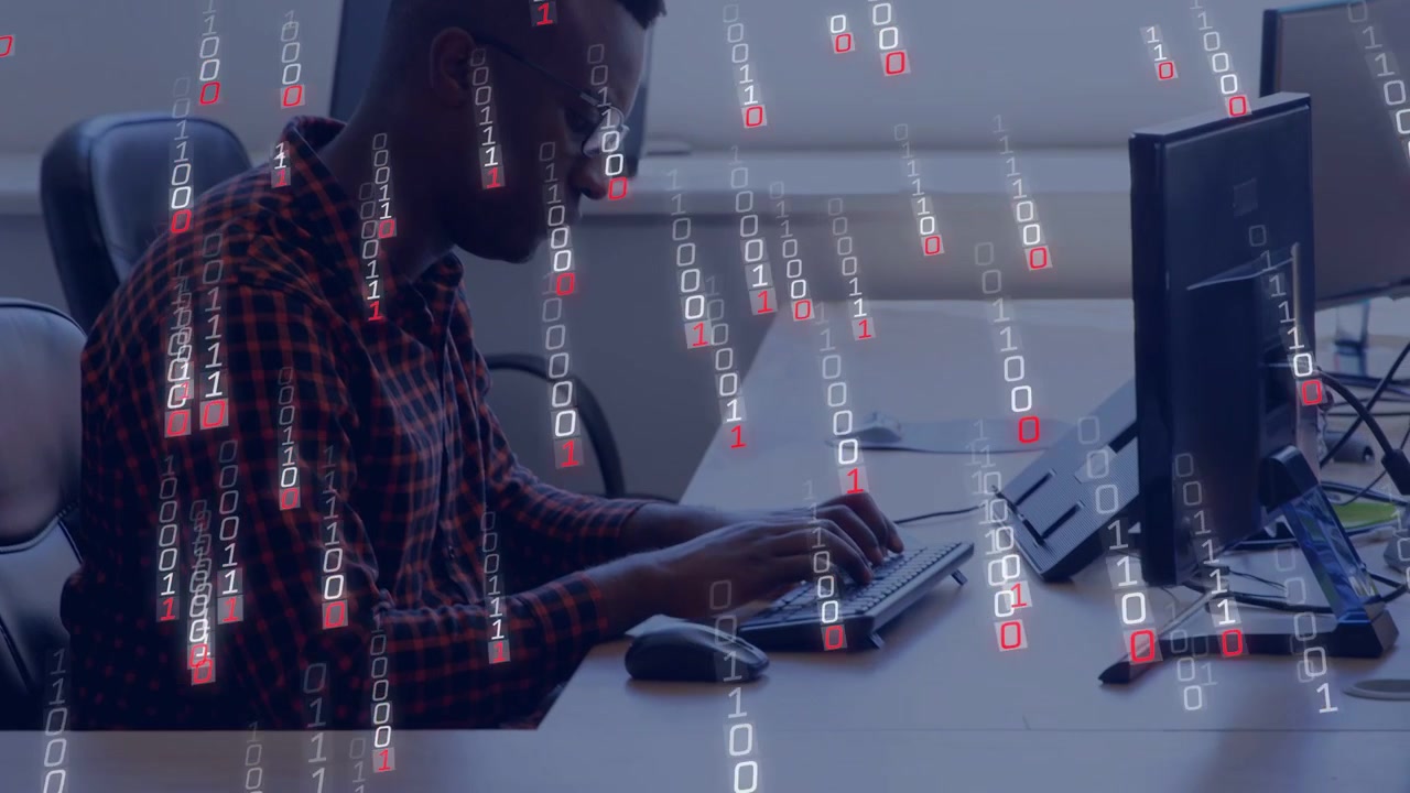 Man typing on keyboard and causing binary overlay growing across dual monitors for technology demo