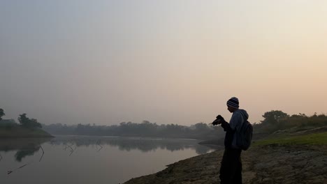 Photographer-capturing-polluting-river,-hazy-polluted-sky,-Bangladesh,-static