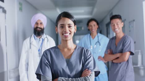 Portrait-of-diverse-doctors-and-nurses-smiling-in-corridor-at-hospital,-in-slow-motion