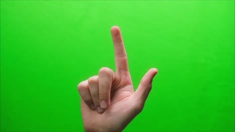 primer plano de un gesto de la mano sobre un fondo verde, gesto del dedo índice hacia arriba, dedo índice, toma de un gesto en el estudio