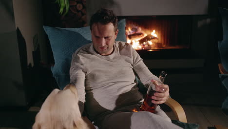 man relaxing by the fireplace with his dog