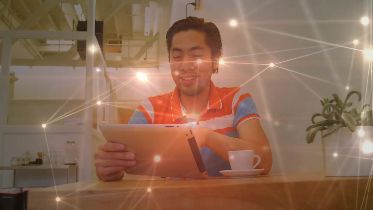 Man placing tablet on table in cafe, browsing data and causing network nodes glowing around him