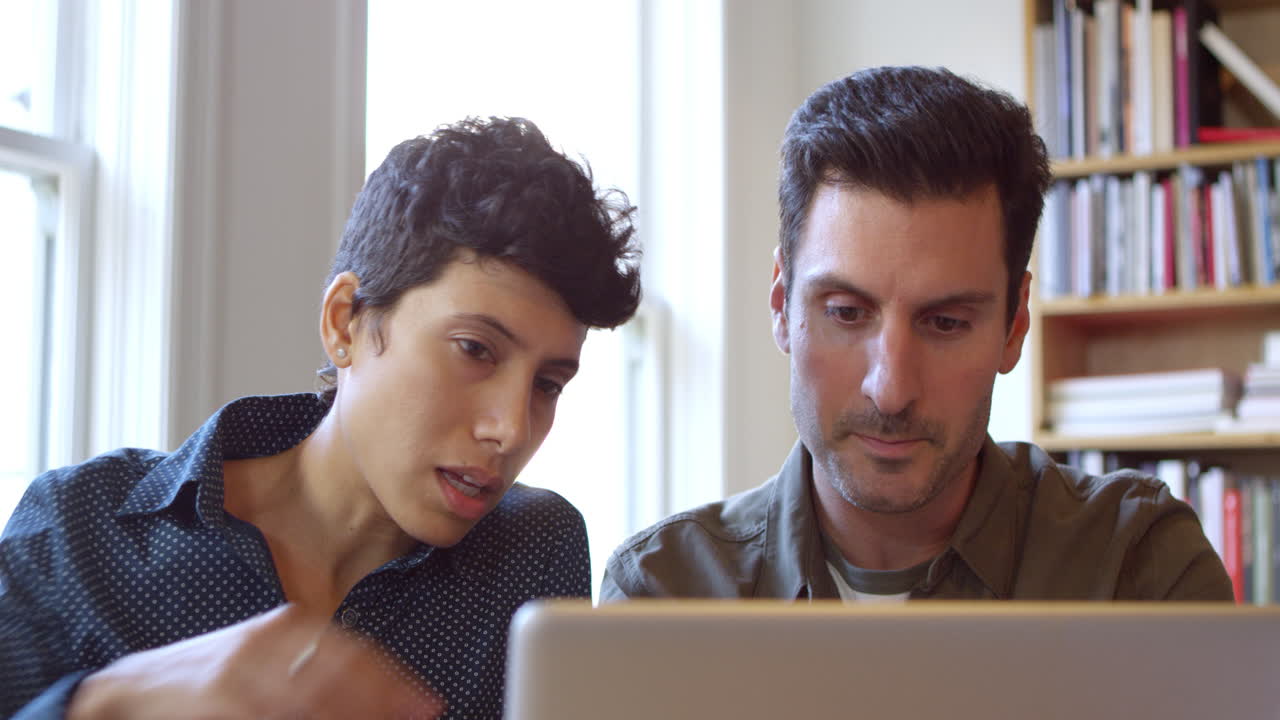 hombres de negocios usando computadora portátil en el escritorio en la oficina filmado en r3d