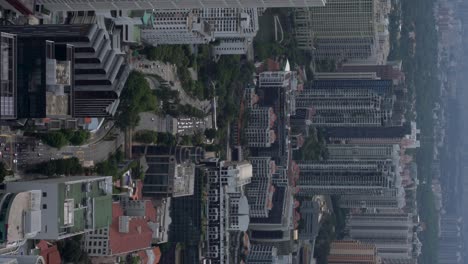 vertical video - densely populated downtown singapore, cityscape including many skyscrapers and street traffic