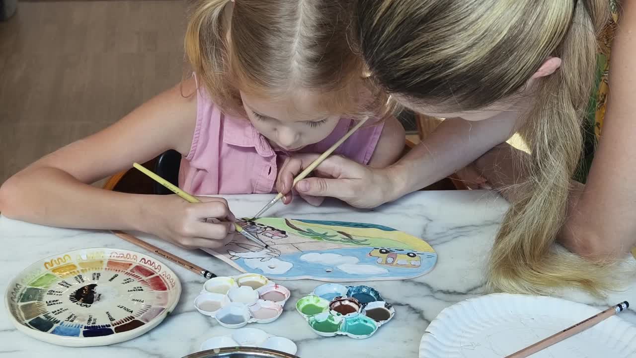 Mãe e filha pintando juntas
