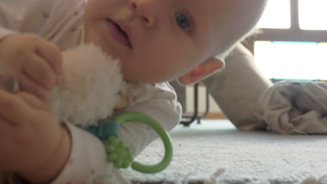 a closeup of a baby girl lying on a carpet with a toy