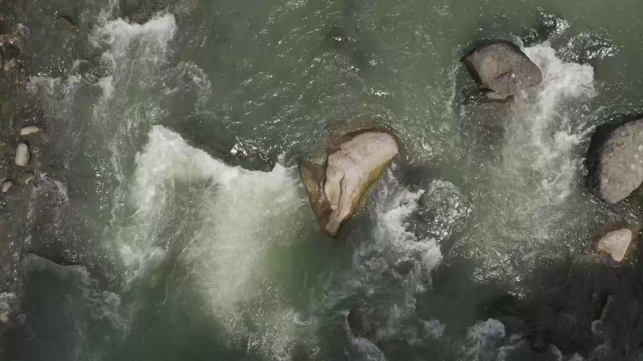 Sterke waterstroomversnellingen die langs grote rotsen in een rivier stromen