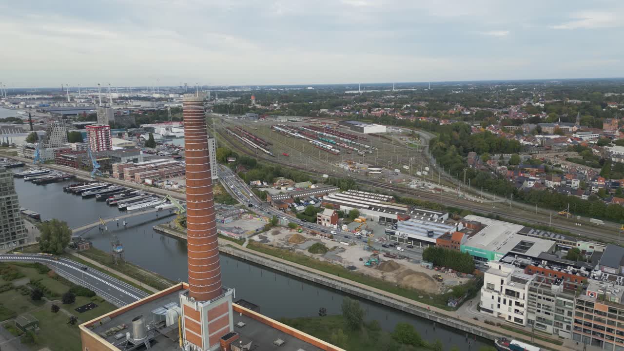 Aerial view of an industrial area with a tall smokestack in Ghent