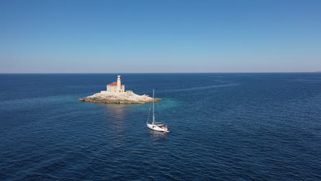 Vista-Aérea-Del-Barco-Y-El-Faro-En-Una-Pequeña-Isla-En-El-Mar-Adriático,-Croacia