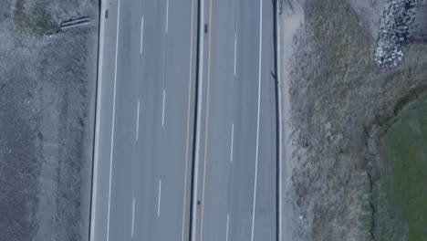 Vuelo-Aéreo-Sobre-Vista-De-Pájaro-Puente-De-Paso-Elevado-Autopista-Con-Caminos-Rocosos-Junto-A-Exuberantes-Parques-Verdes-Césped-En-Un-Caluroso-Día-De-Verano-Dolly-Rool-Pequeños-Arbustos-Camioneta-Blanca-Con-Capota-Blanda-Negra