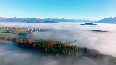 misty woodlands and pastures on the swiss plateau with savigny village in vaud, switzerland - aerial drone shot