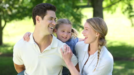 Padres-Felices-Con-Su-Niña-En-El-Parque