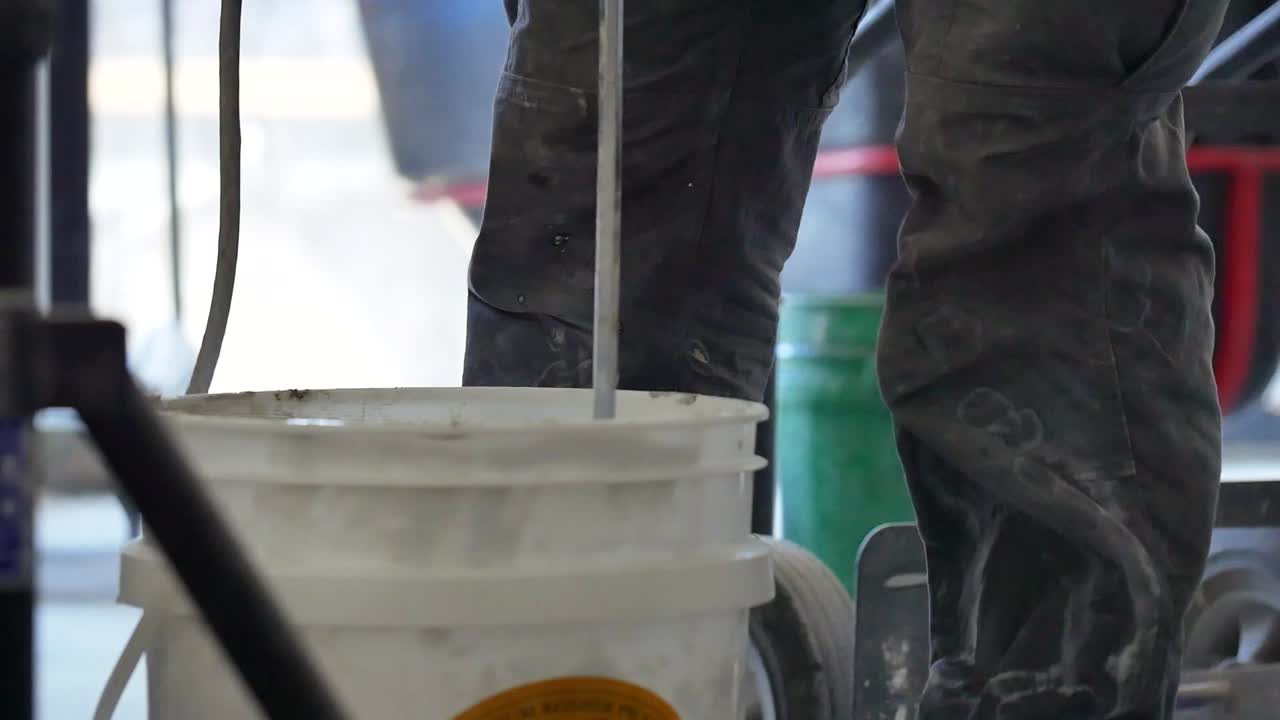 trabajador de la construcción mezcla hormigón con un mezclador