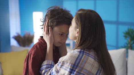 Emotional-mother-kissing-her-son-at-home-and-looking-at-him-proudly.