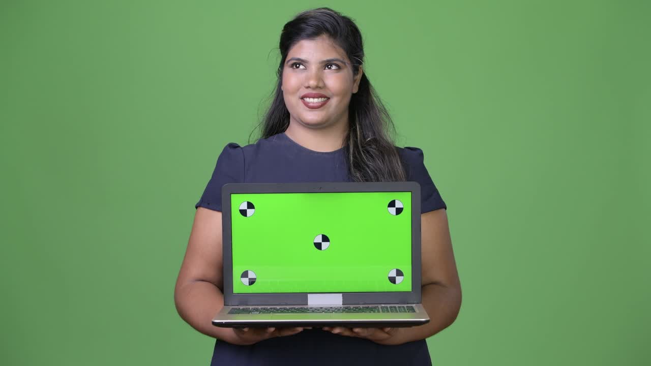 joven sobrepeso hermosa mujer de negocios india contra fondo verde