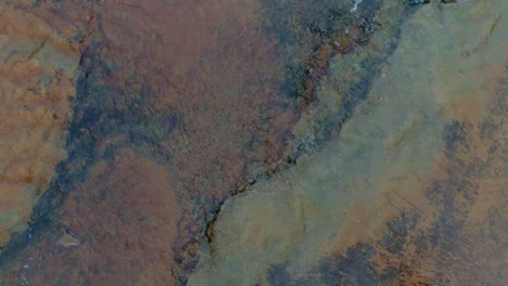 aerial brids eye shot ascending above cedar creek, peaceful flowing water over colorful rock bottom