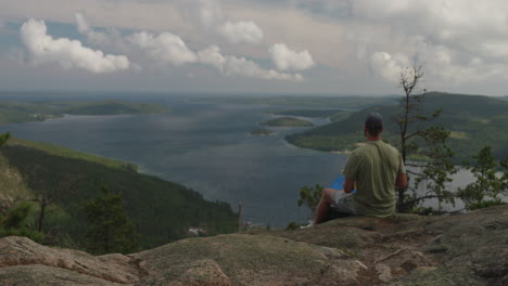 Man-seated-with-his-back-to-the-Swedish-flag-in-his-hand-looking-at-high-coast