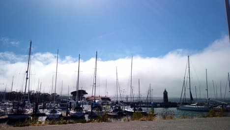 lapso de tiempo de nubes y niebla rodando sobre el puente golden gate y el puerto deportivo en san francisco, california