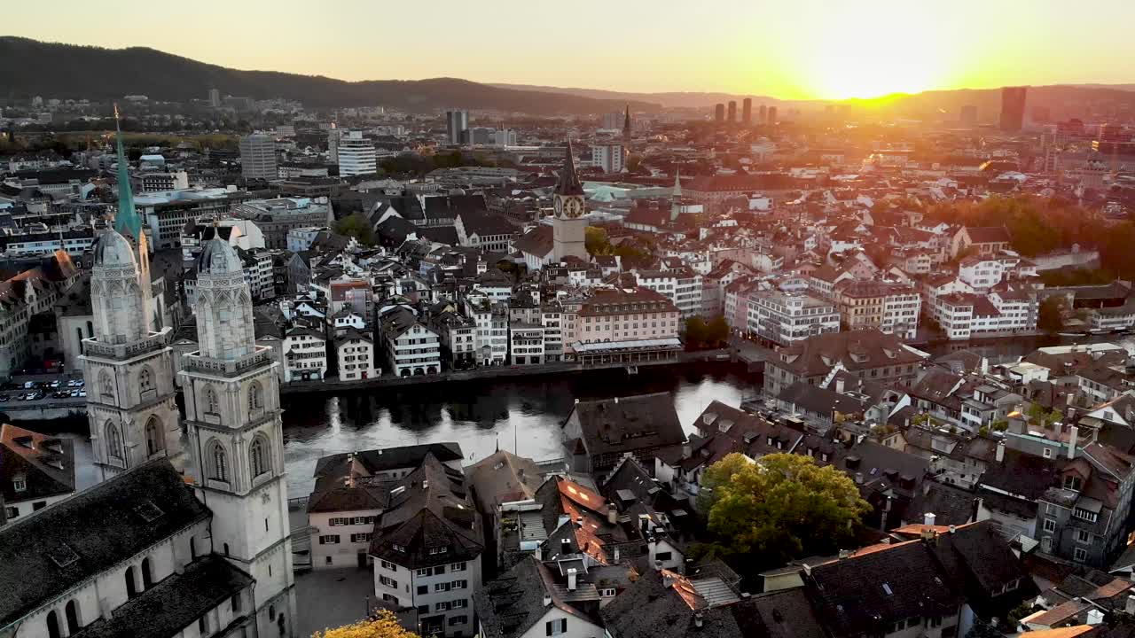 paso elevado aéreo junto al río limmat en zurich, suiza al atardecer detrás de la iglesia de grossmünster