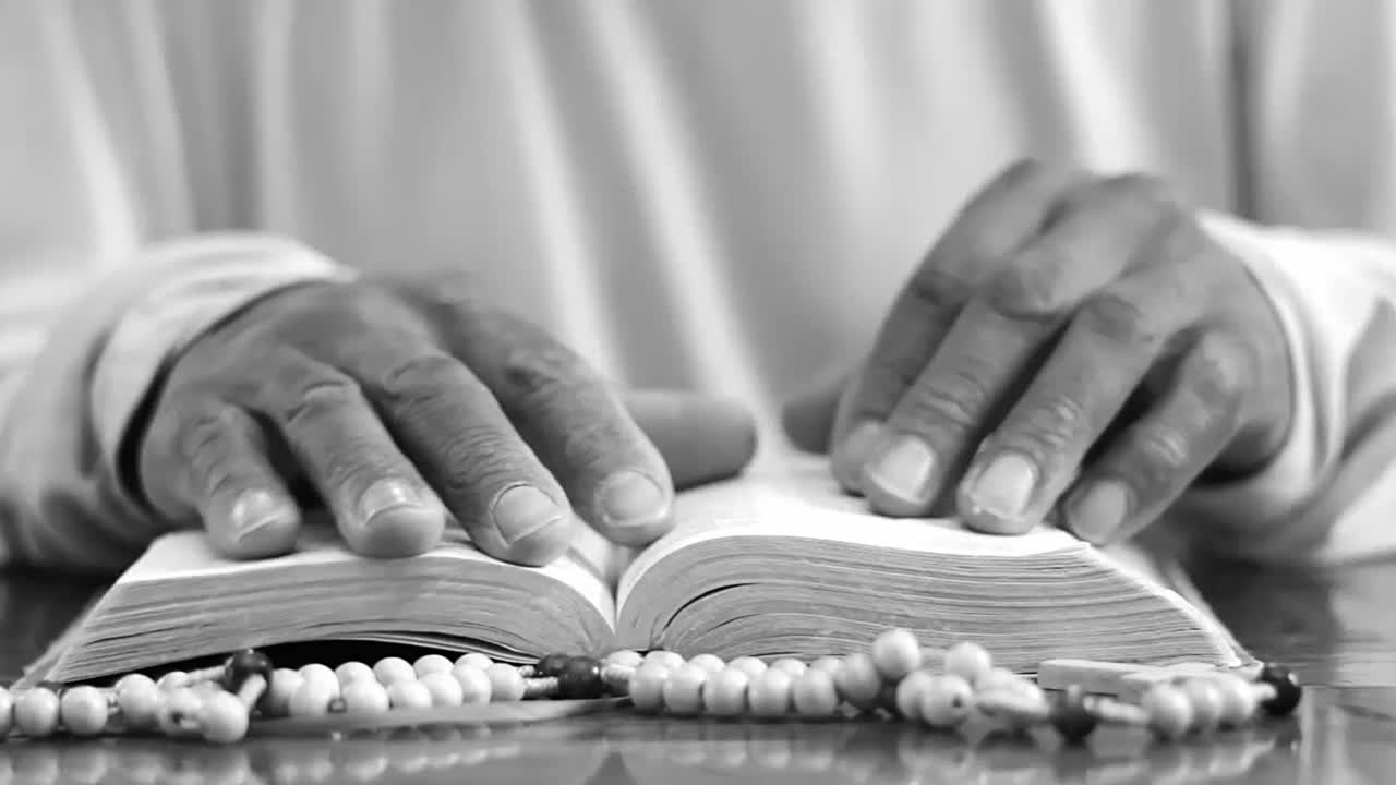 Mani che pregano Dio su una Bibbia con persone - Filmato video in stock