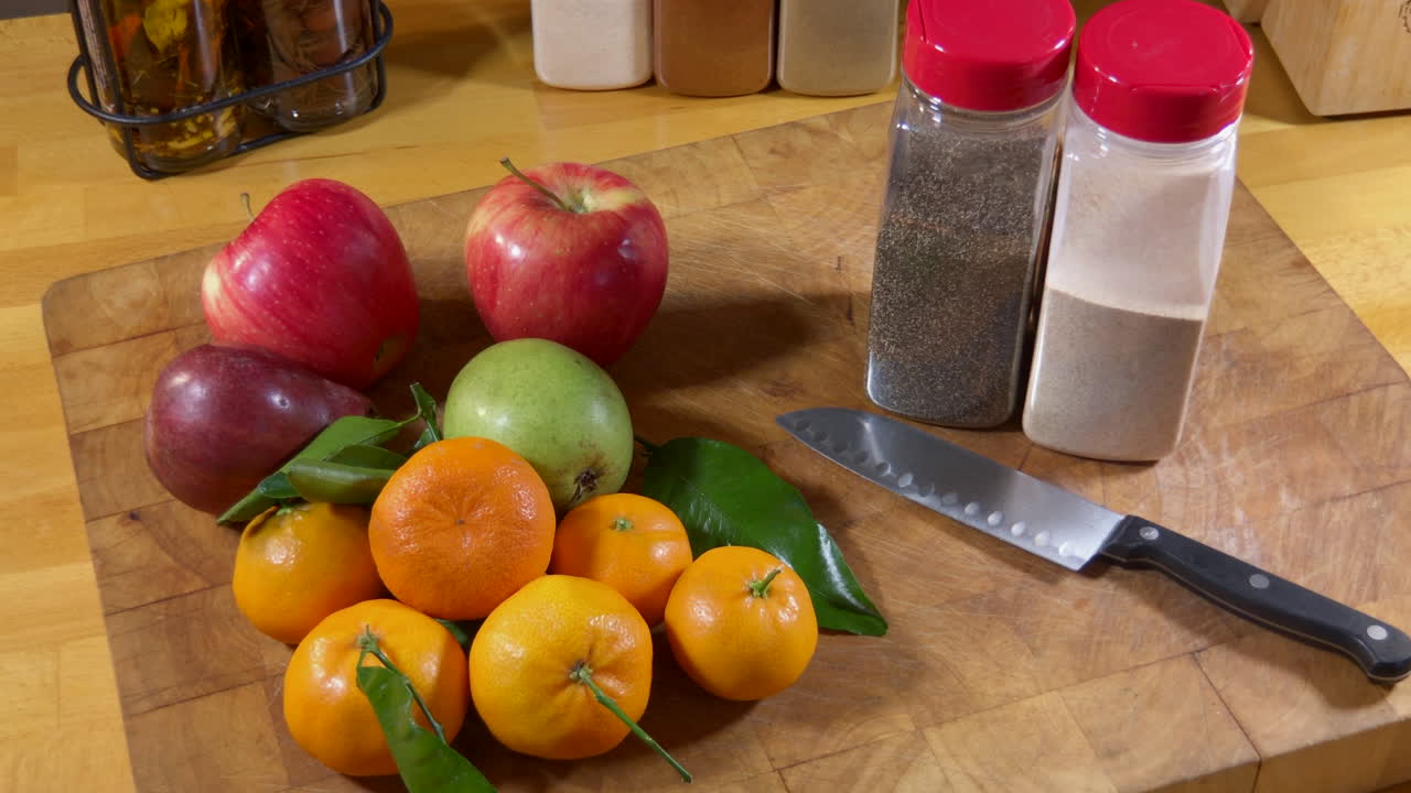 Beauty shot, apples, pairs and mandarin oranges on cutting board with knife