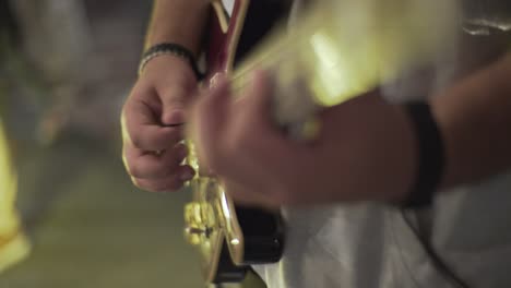 a man playing on an electric guitar in the theatre static shot, close up shot, insert shot