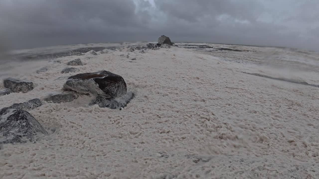 Ocean Foam Blown By Strong Wind At Currumbin Beach. Cyclone Alfred In Queensland, Australia. static shot
