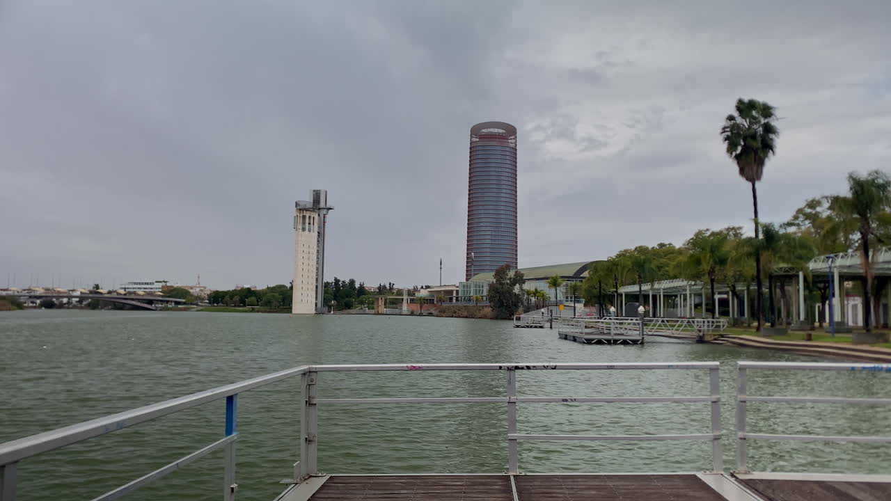 Paisaje urbano de Sevilla con arquitectura moderna como la Torre Sevilla y la Torre de la Navegación a lo largo del río Guadalquivir.
