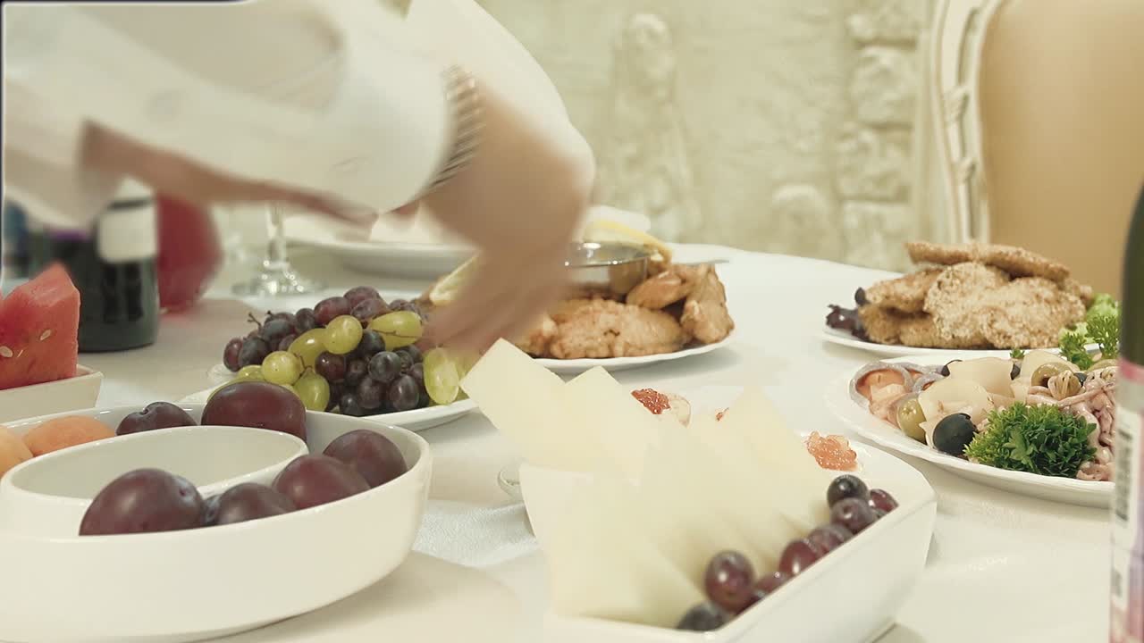 The waiter serves the table Rearranges food