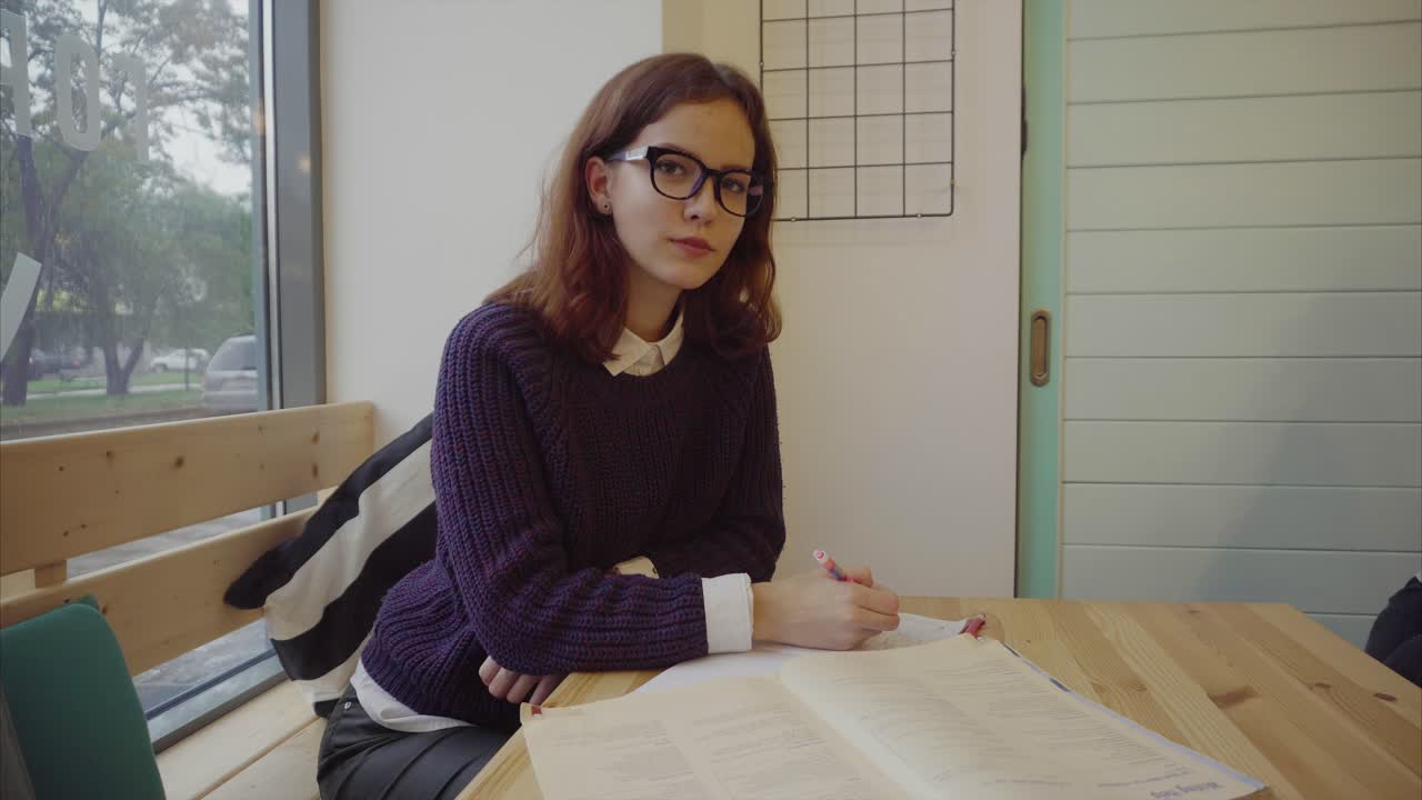 una adolescente estudiando en un café