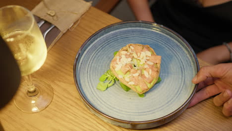 hand of the waiter leaving the blue dish for dinner in the restaurant
