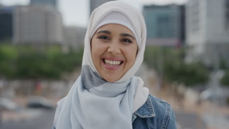 Retrato-Joven-Hermosa-Mujer-Musulmana-Riendo-Disfrutando-De-Un-Exitoso-Estilo-De-Vida-Urbano-Estudiante-Independiente-Usando-Velo-Hijab-En-El-Viento-De-La-Ciudad