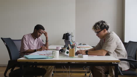 two men working at a desk in a modern office.