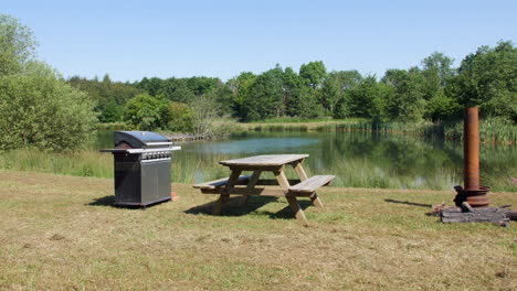 BBQ-and-picnic-wooden-bench-next-to-a-beautiful-lake