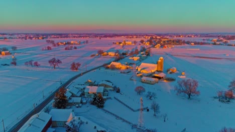 Una-Vista-Aérea-De-Las-Tierras-De-Cultivo-Del-Campo-Después-De-Una-Caída-De-Nieve-Temprano-En-La-Mañana-Durante-La-Hora-Dorada