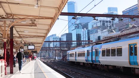 train arrives at a busy melbourne platform