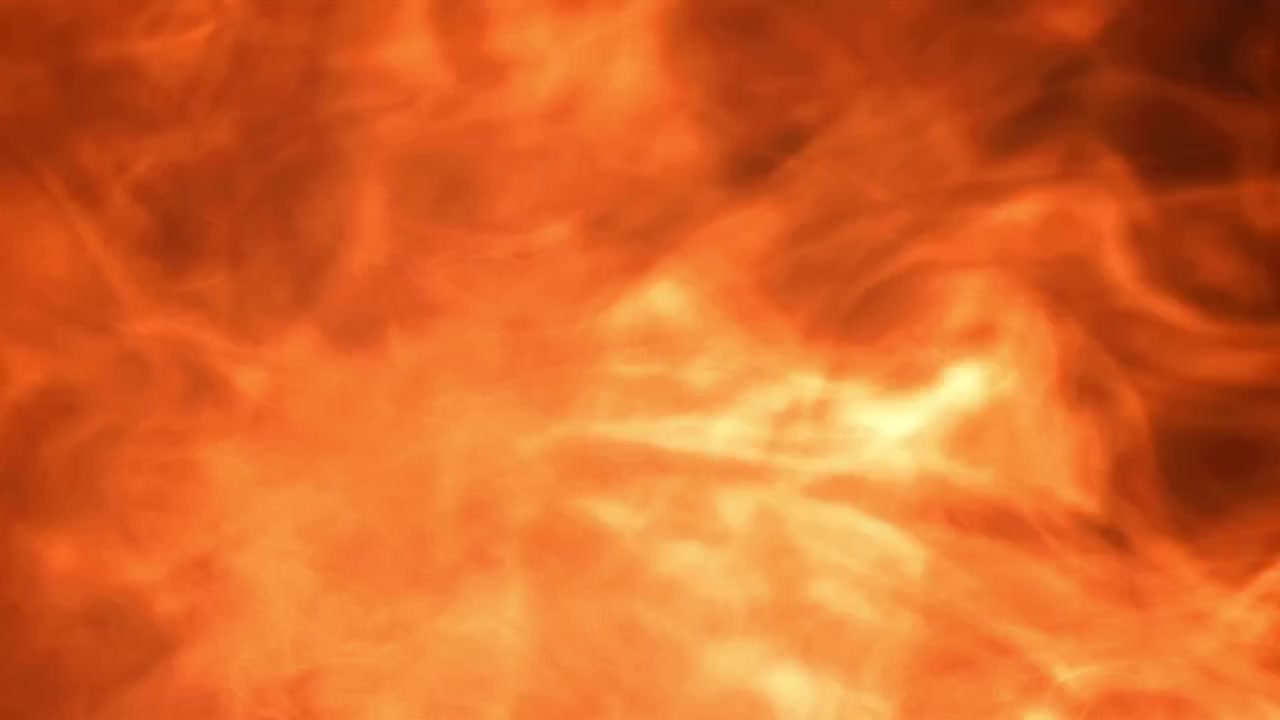 Dynaaminen oranssi ja keltainen savu leviämässä mustalla taustalla