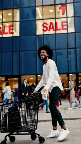 joyful man with a shopping cart in front of a store with a sale sign