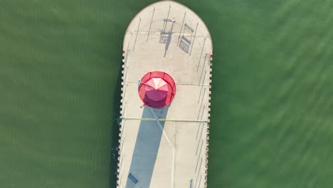 an old lighthouse with worn paint in direct aerial