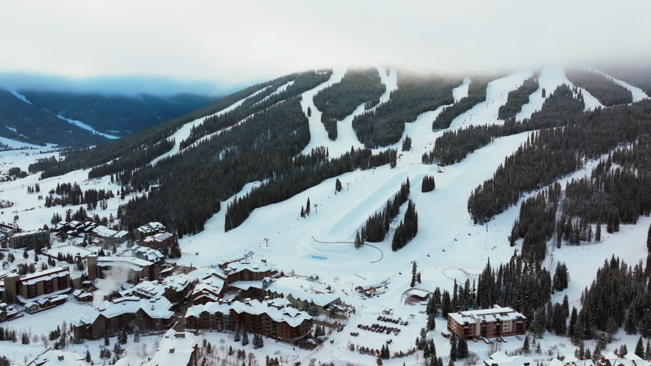 montaña de cobre colorado capa de nubes de niebla invierno nevado temprano en la mañana amanecer drone aéreo estación de esquí i70 águila volador ascensor centro aldea media tubería icon paso épico snowboarding hacia atrás lentamente pan up