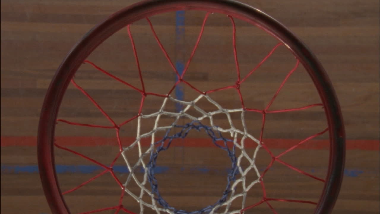 человек бросает баскетбольный мяч в обруч и подбирает его, когда он подпрыгивает