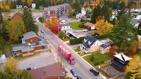 mont tremblant village surrounded by autumn forest, colorful leaves highlighting the quaint neighborhood as truck drives through town