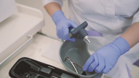 detail of unrecognizable doctor's hands assembling an otoscope