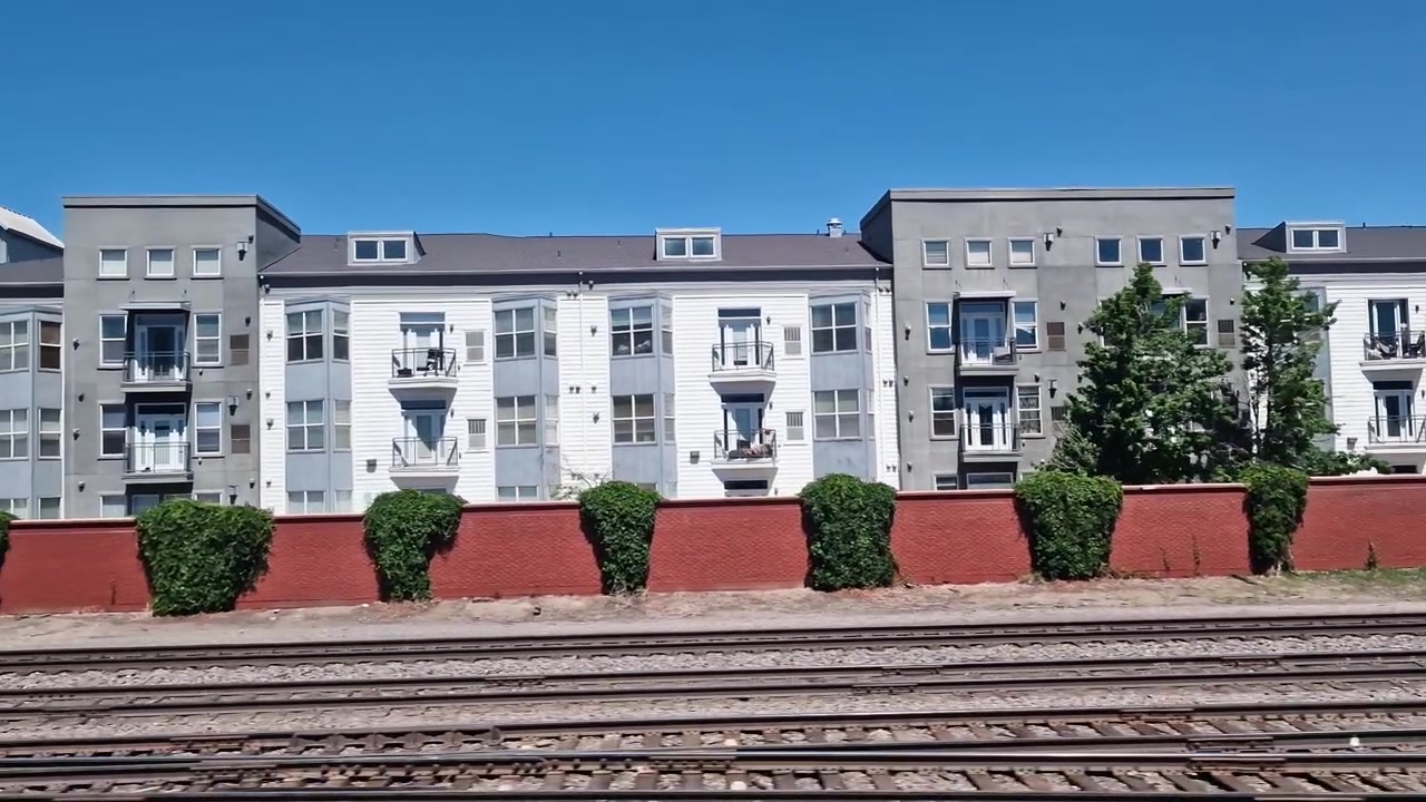 Boligbygninger langs jernbanen nær Union Station og sentrum av Denver Colorado USA, fra togpassasjerens perspektiv.